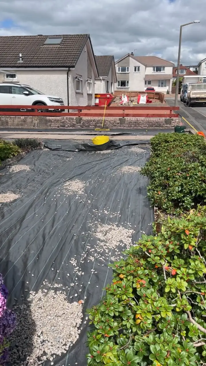 Weed membrane being laid during a garden landscaping project