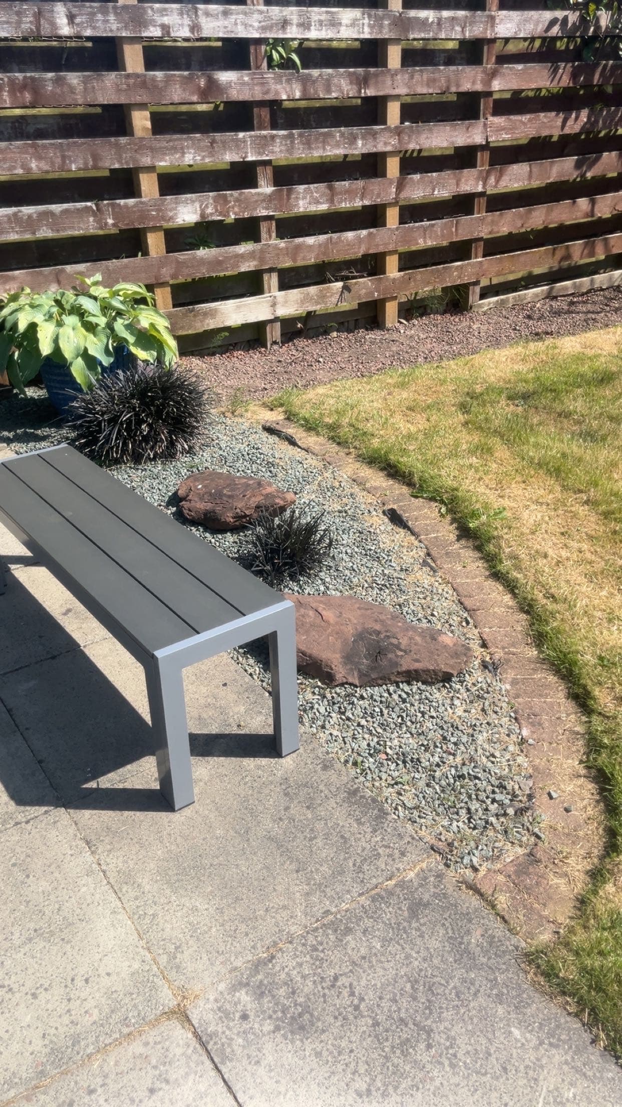 Garden landscaping with grey stone, feature rocks and a seating area completed by RML Ground Maintenance in Dumfries and Galloway